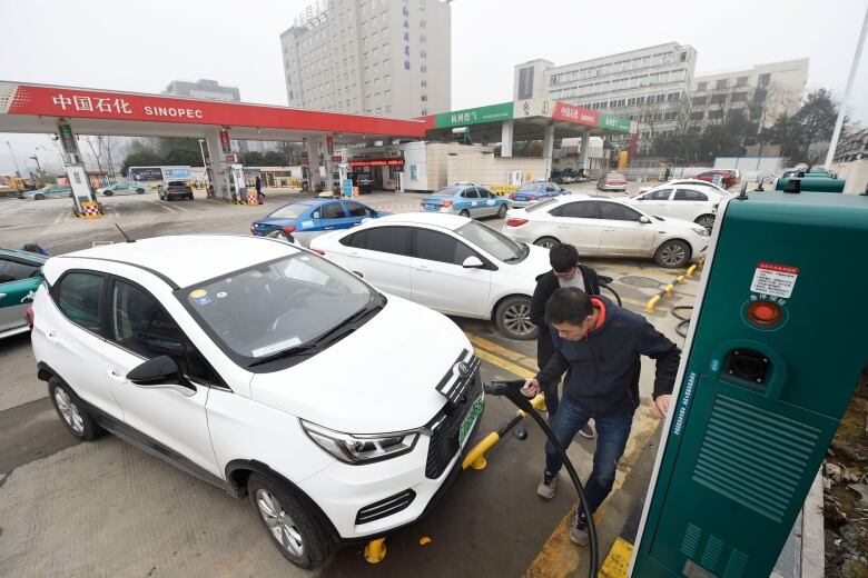 People charge an electric car in China.