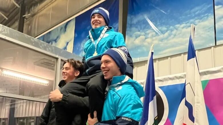 Three jubilant young men in triangle formation.