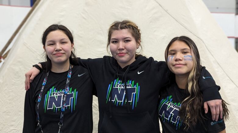 Three girls, Gabrielle McLeod, Jerrica Sanderson and Desiree Charlo, pose hands over shoulders in Gym at AWGs