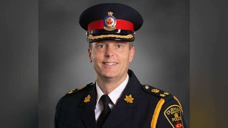 A man in a police uniform poses for a portrait.