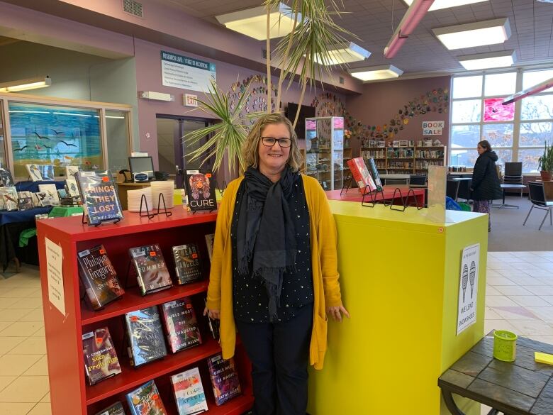 A woman standing in the main lobby of a library.