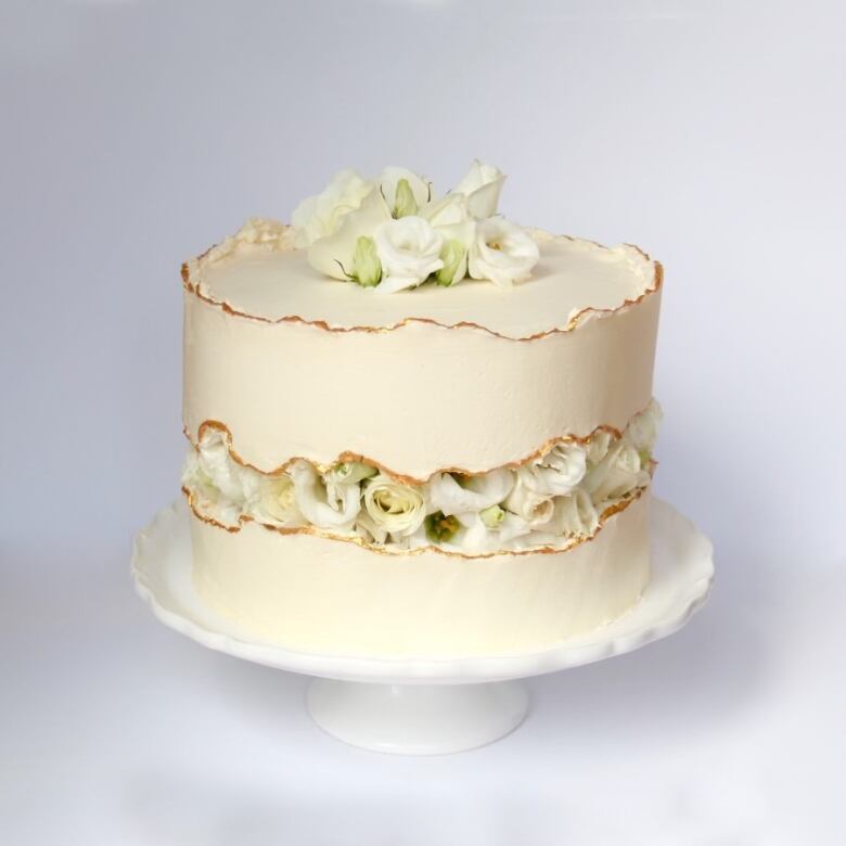 A white chocolate cakes includes a layer in the middle of edible white flowers.