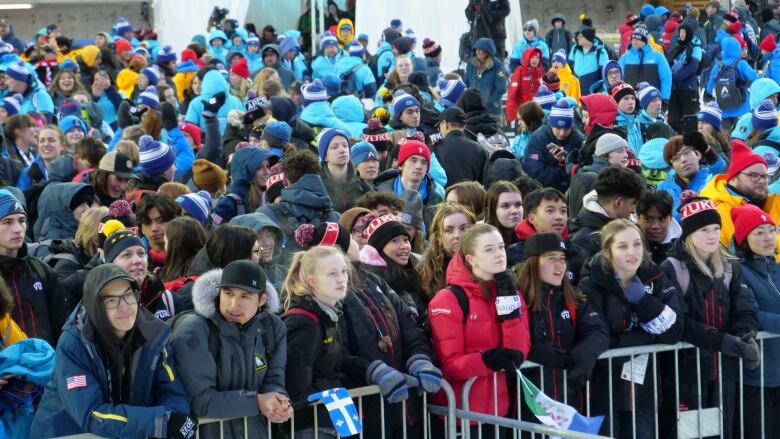 Crowd of people near fence.