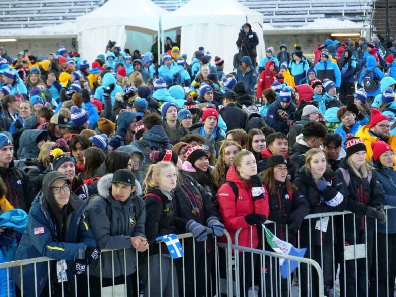 Crowd of people near fence.