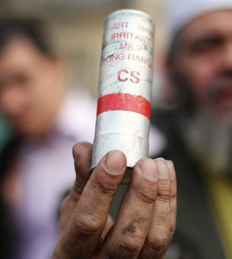 An Egyptian protester holds a CS gas canister in Tahrir Square in Cairo, Egypt, Wednesday, Nov. 30, 2011. Egypt's military rulers are taking credit for the strong turnout in the country's first parliamentary elections since the ouster of Hosni Mubarak, the head of the election commission proclaims that the turnout so far is 'massive and unexpected.' (AP Photo/Manu Brabo)