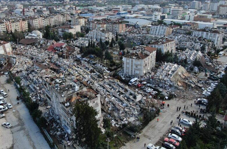 An aerial view shows collapsed buildings.