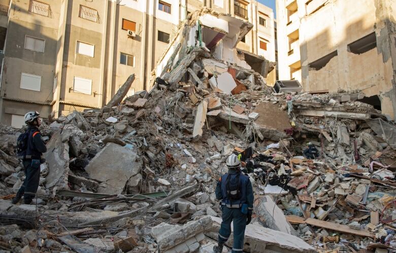 Rescuers search for survivors amid the rubble of a collapsed building.