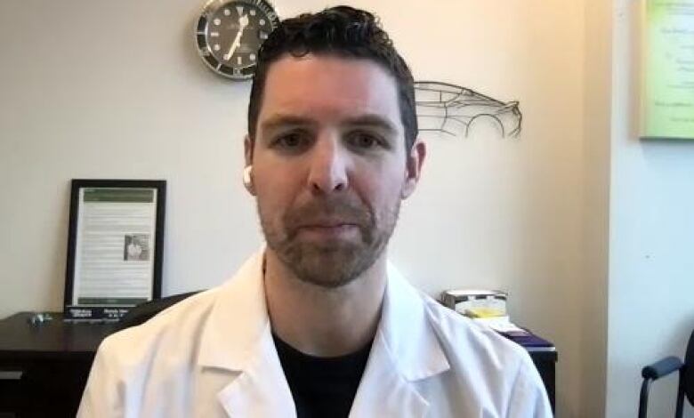 Pharmacist Randy Howden is dressed in a lab coat as he looks directly into the camera from an office.