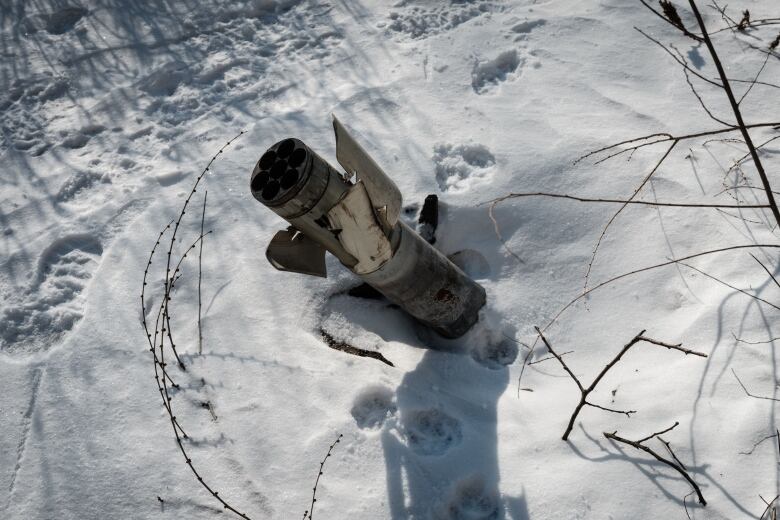 A portion of a rocket, sticking out of snow-covered ground in Avdiivka, Ukraine.