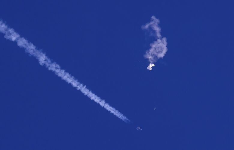 Trails from an aircraft are shown in the sky, along with a white object.