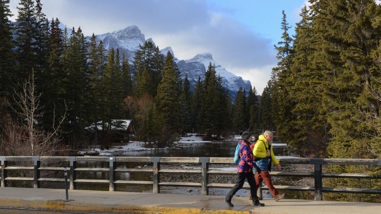 A couple walk over Policeman Creek in Canmore.