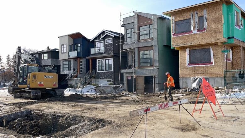 A residential street has been left with a gaping hole as a number of new infill homes are being built in the background in southwest Calgary.