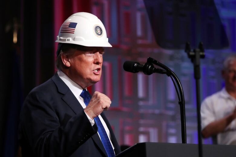 U.S. President Donald Trump dons a hard hat presented by the National Electrical Contractors Association (NECA) before addressing their convention in Philadelphia, Pennsylvania, U.S., October 2, 2018. REUTERS/Jonathan Ernst