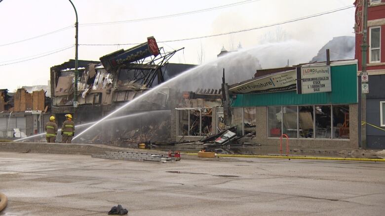 Firefighters were still spraying water on what's left of three Main Street businesses that burned Sunday.