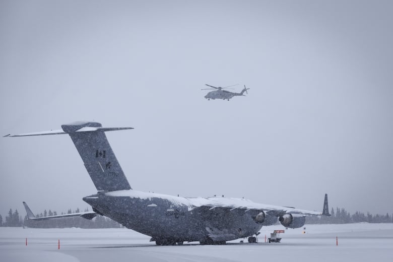 A helicopter is seen flying through winter weather in the Yukon.