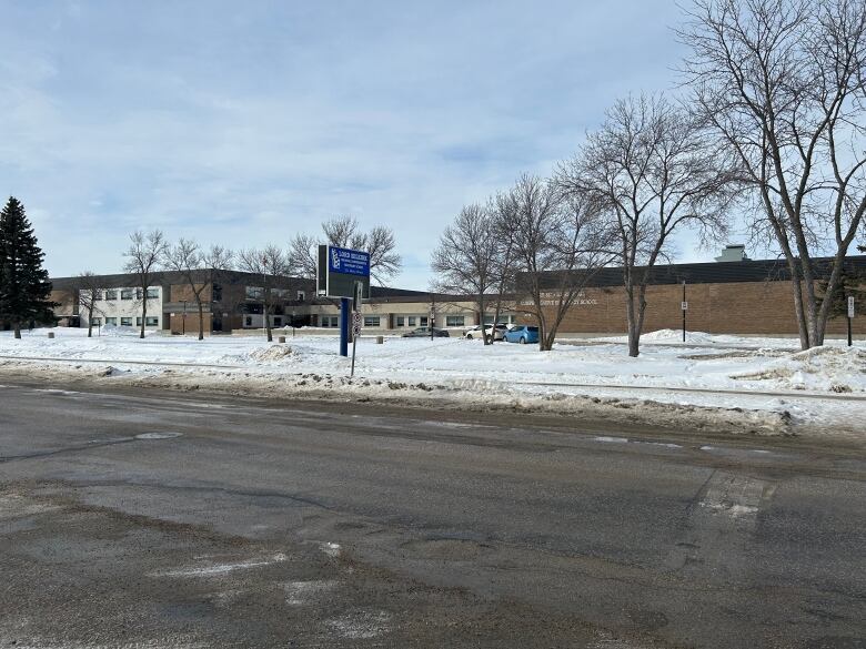 A large brown school is pictured on a winter day.