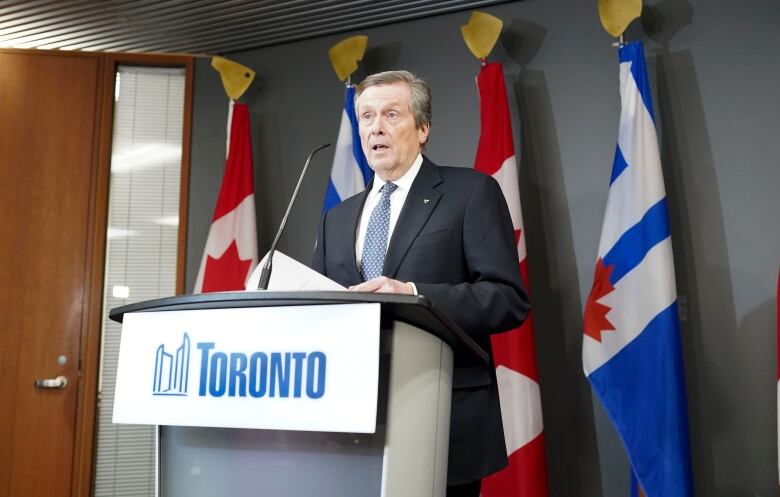 Toronto Mayor John Tory stands at a podium. 