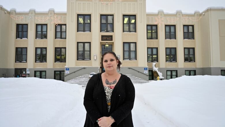 Woman in front of multi-storey building.