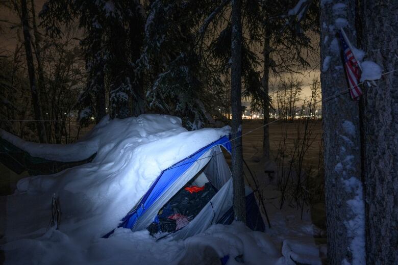 Snow covered tent frame in the dark. 