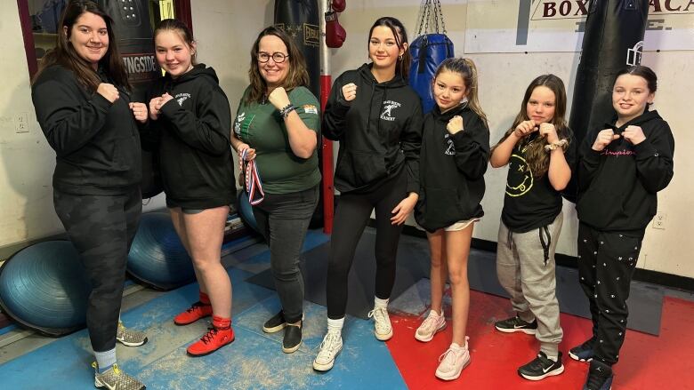 A group of girls and women pose in a boxing stance