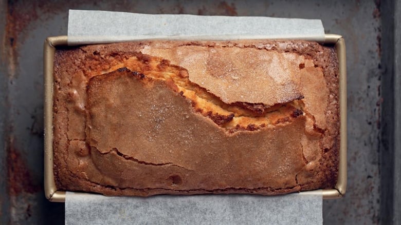 an overhead shot of a pound cake in a loaf pan on top of a baking sheet