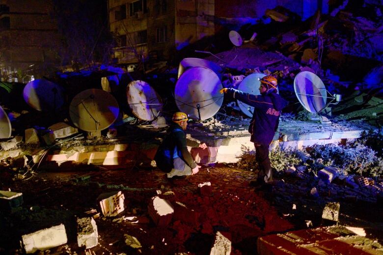 Rescuers search through the rubble of a damaged building.