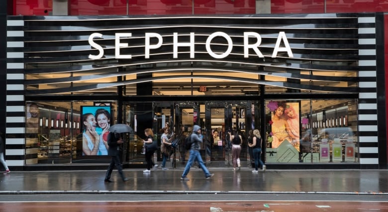 Pedestrians walk by a large Sephora cosmetics store.