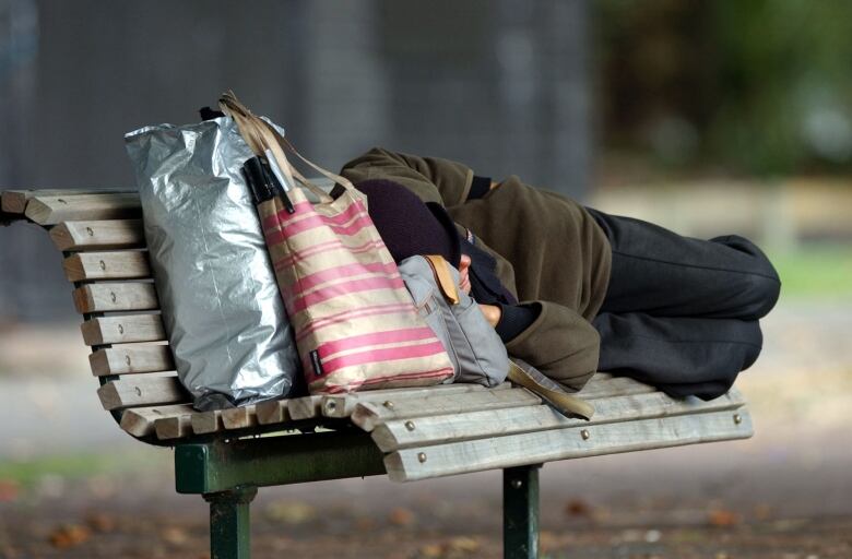 A man sleeps on the bench.