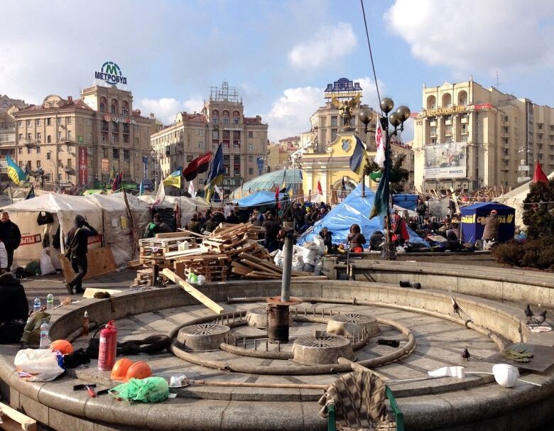 A city square with tents and debris.