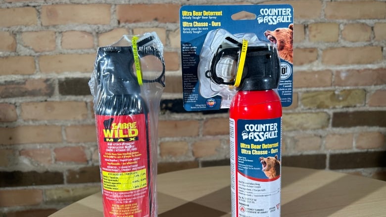 Two red canisters containing images bears and product warnings are pictured on a table.