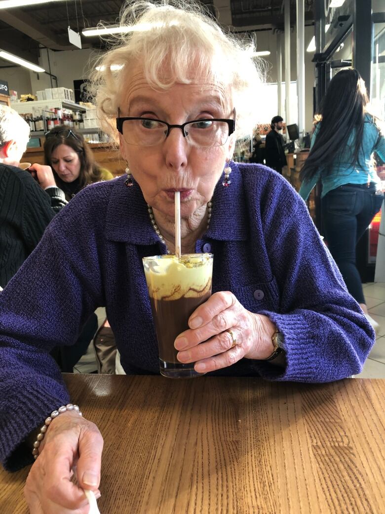 A woman sips on a beverage through a straw.