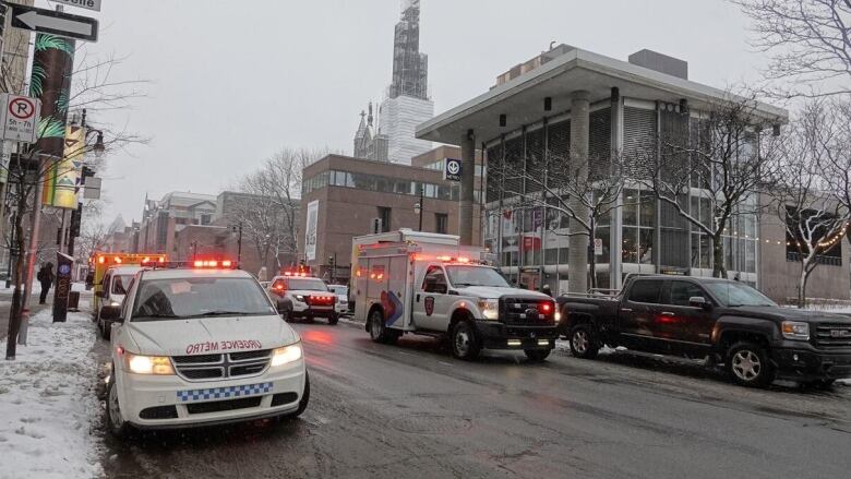 Police and Metro police emergency vehicles are parked outside a downtown Metro station on a wintry day.