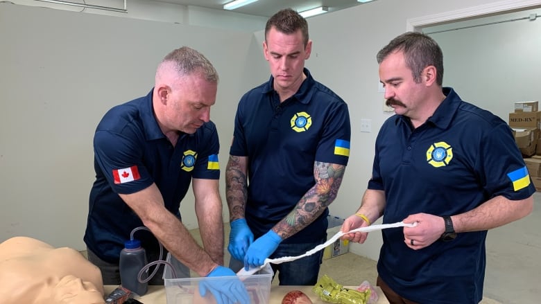 Kevin Royle, Nelson Bate and Anatoli Morgotch of Firefighter Aid Ukraine do a first aid demonstration at the organization's warehouse in Edmonton.