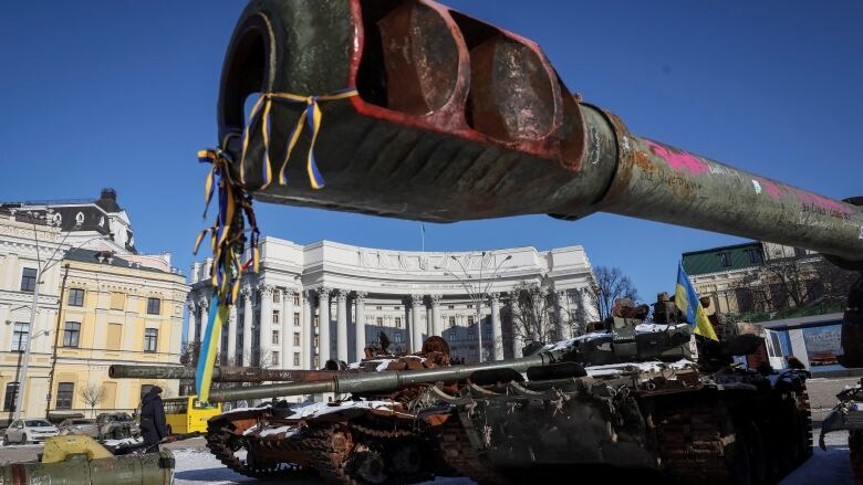 Rusted tanks sit in an urban square.