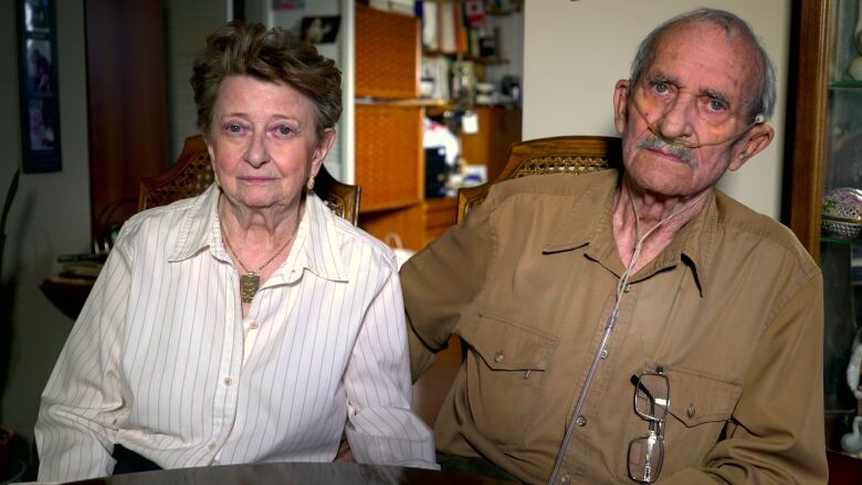 An elderly couple sitting at a table. 