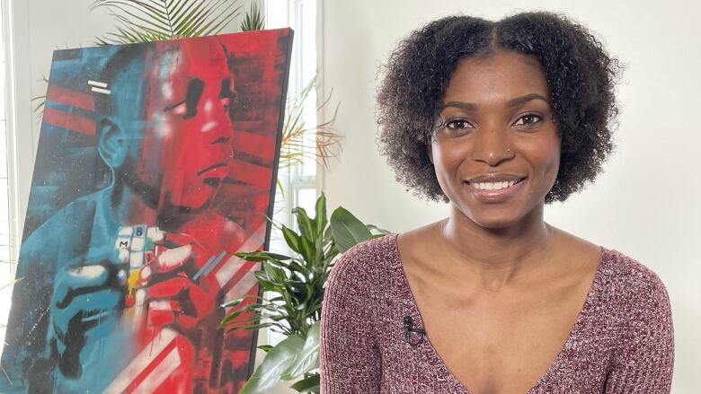 Artist Sydonne Warren is shown next to some of her artwork.