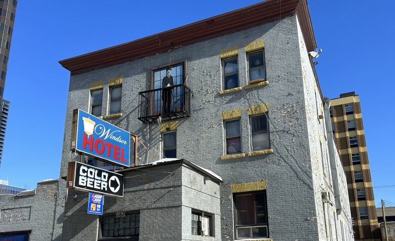 A three-storey brick building can be seen in this photo. A sign on the front says 