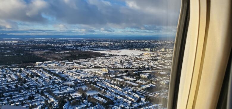 An aerial photo from a plane shows Metro Vancouver buildings blanketed in snow. 