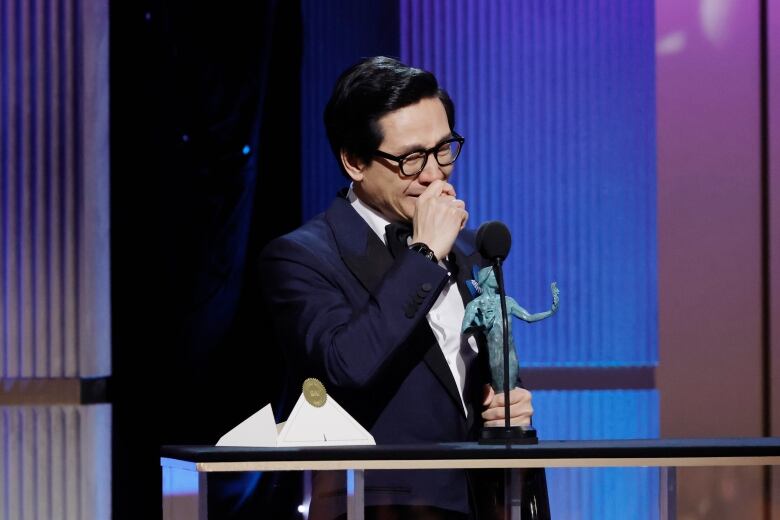 An actor reacts after accepting an award.