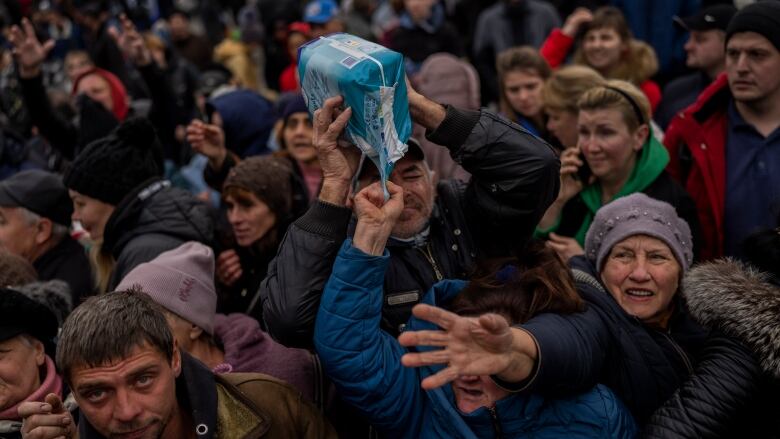 Residents gathering at an aid distribution point receive supplies in downtown Kherson, southern Ukraine, on Friday, Nov. 18, 2022.