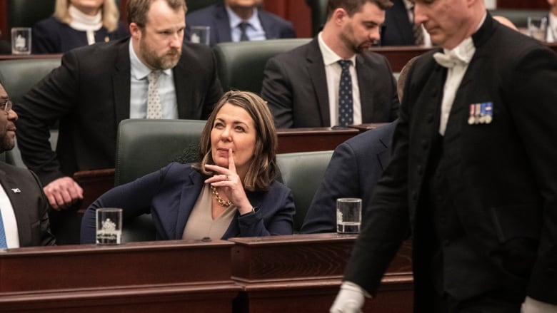 Alberta Premier Danielle Smith rests a finger by her mouth and she sits in the Alberta legislature, waiting for Alberta Finance Minister Travis Toews to deliver the 2023 budget, in Edmonton on Tuesday, February 28, 2023.