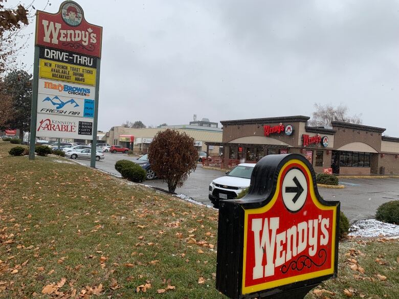 Wide shot of Wendy's restaurant and their signs in a parking lot area.