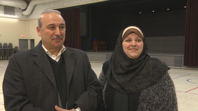 A married couple, Kamal Asi and Faten Asi, speaks to a reporter. 