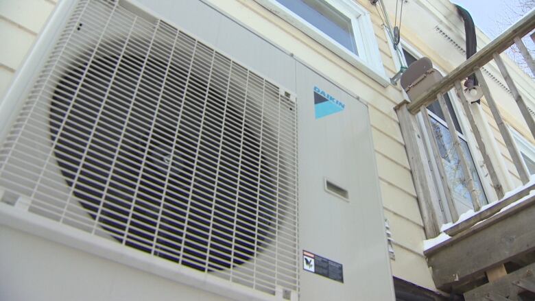 A heat pump system installed outside an apartment.