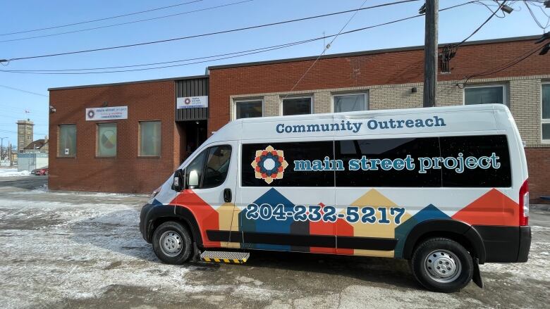 A community outreach truck is seen sitting outside of a building.