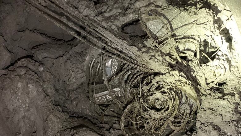 Steel tiebacks hang from the face of a micro-tunnelling boring machine which was being used by the city to create a new storm sewer on Old Mill Drive. This picture was taken underground shortly after contractors working on the project discovered that the vehicle was struck. The operation to remove it has been complicated by mud and water. 