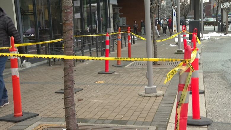 An area is cordoned off with yellow tape and orange cones