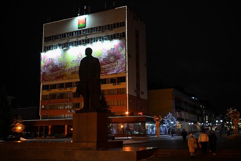 Residents walk past a statue of Soviet state founder Vladimir Lenin in Bryansk, Russia.