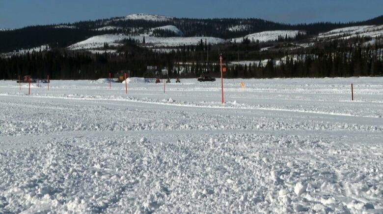 Snowy ground in front of a mountain.