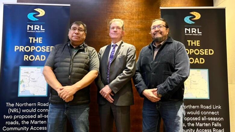 Three men stand together for a photo opportunity after an announcement in Toronto.